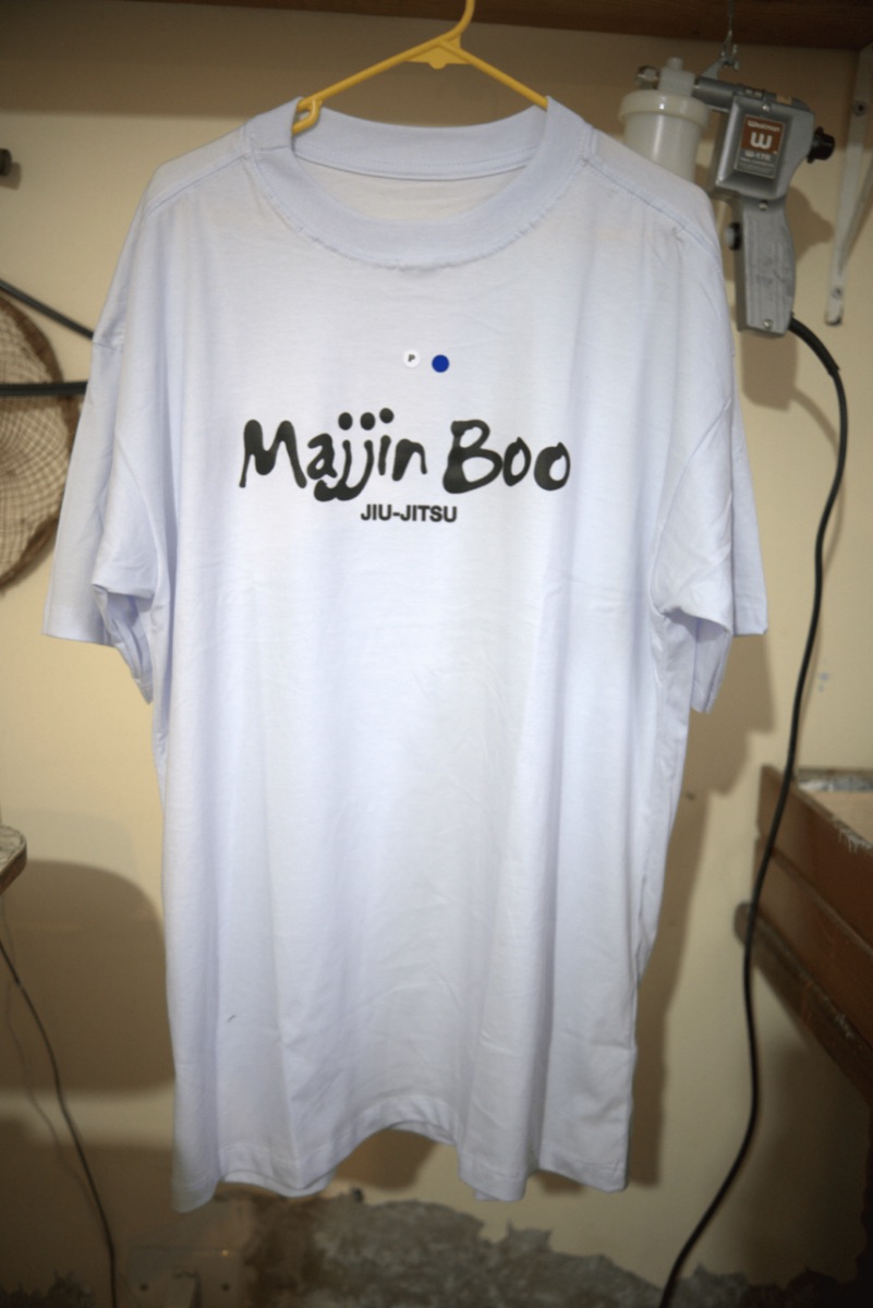 Camiseta branca com estampa Majin Boo Jiu-Jitsu pendurada no ateliê